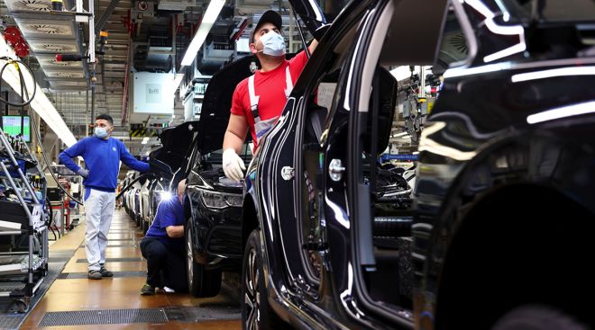 Workers on the Volkswagen Golf 8 automobile assembly line